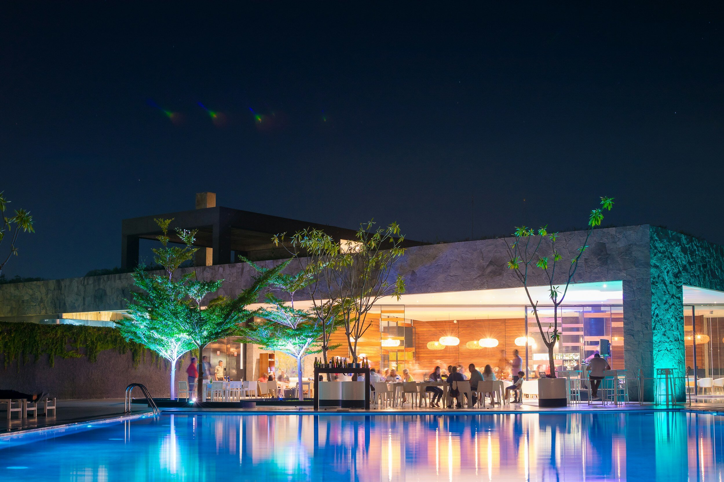 Contemporary private club and pool illuminated at night